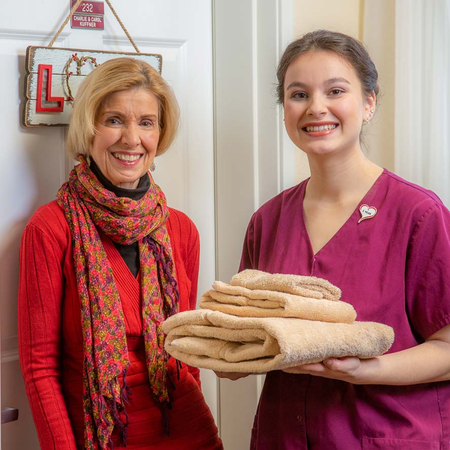 A team member delivering fresh linens to a resident at Julian Estates